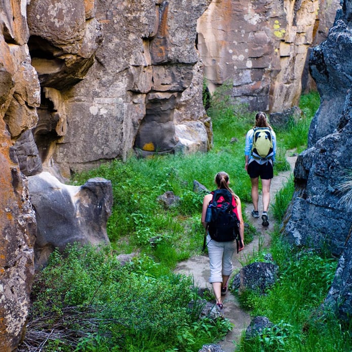 two hikers walking in steep canyon