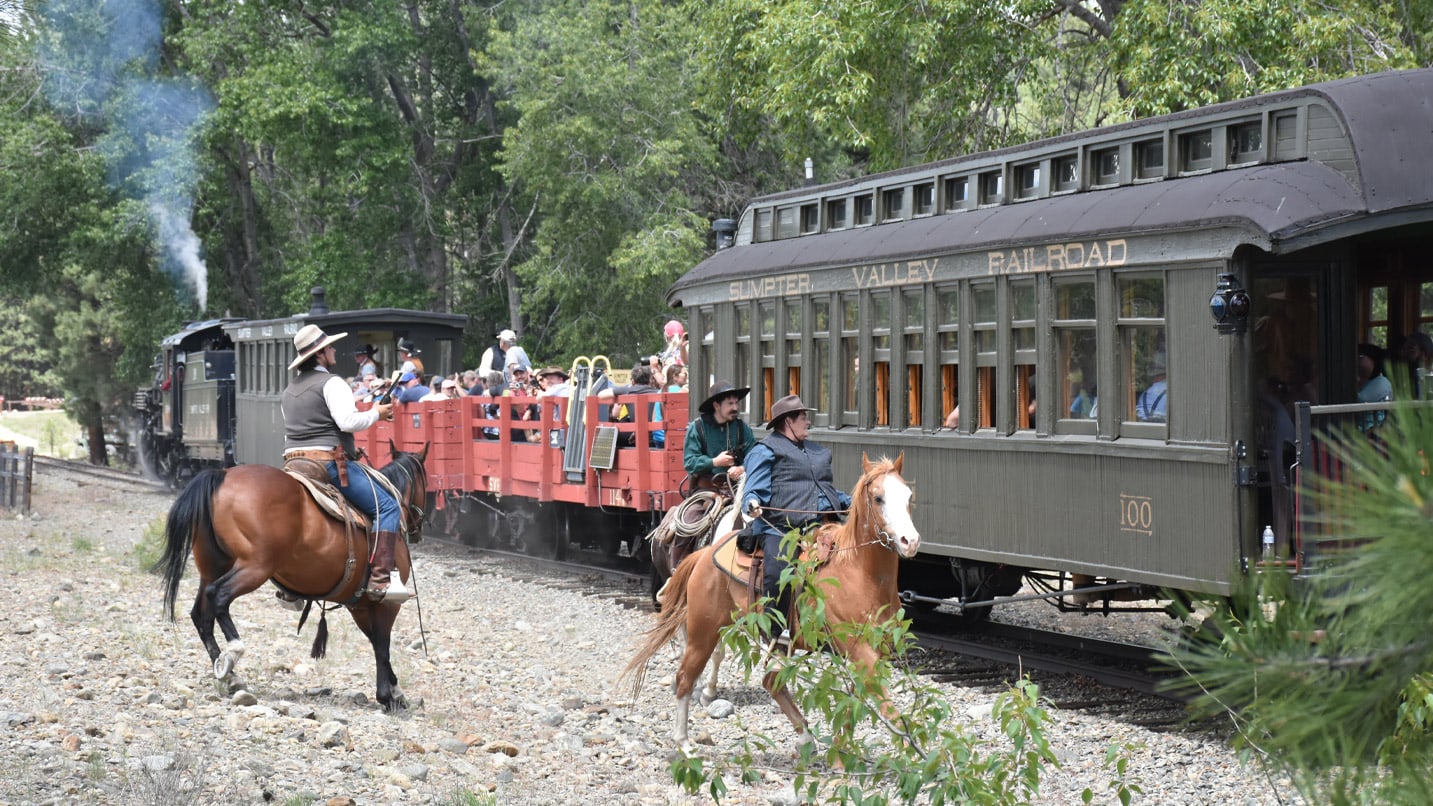 Horseback riders alongside a passenger train