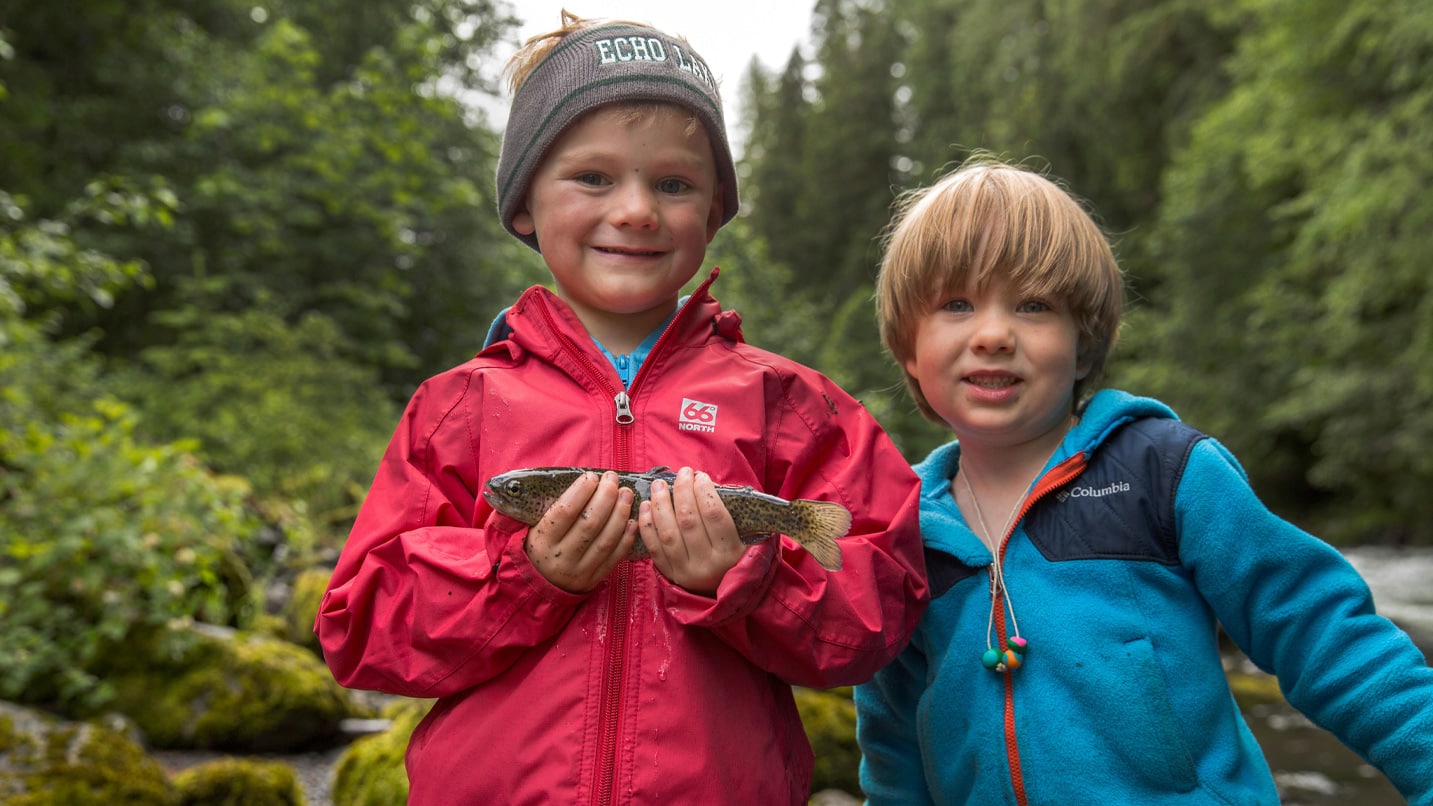 Two children hold a small fish