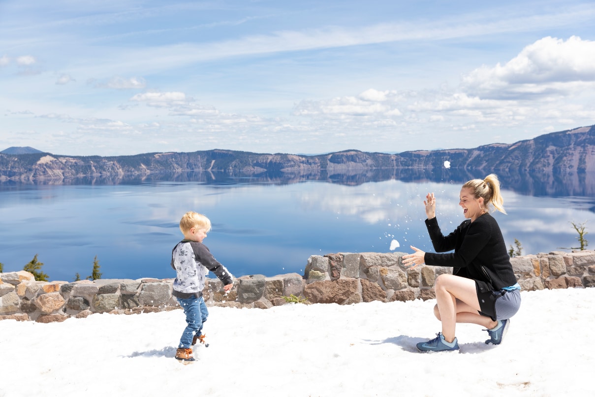 woman and child in snow at crater lake