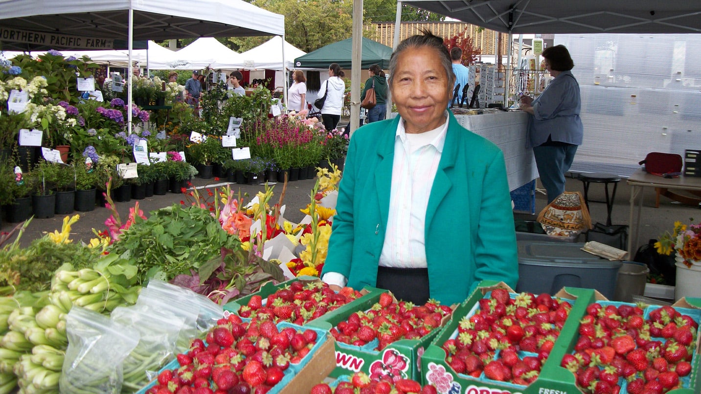 A person stands behind a stand of strawberries