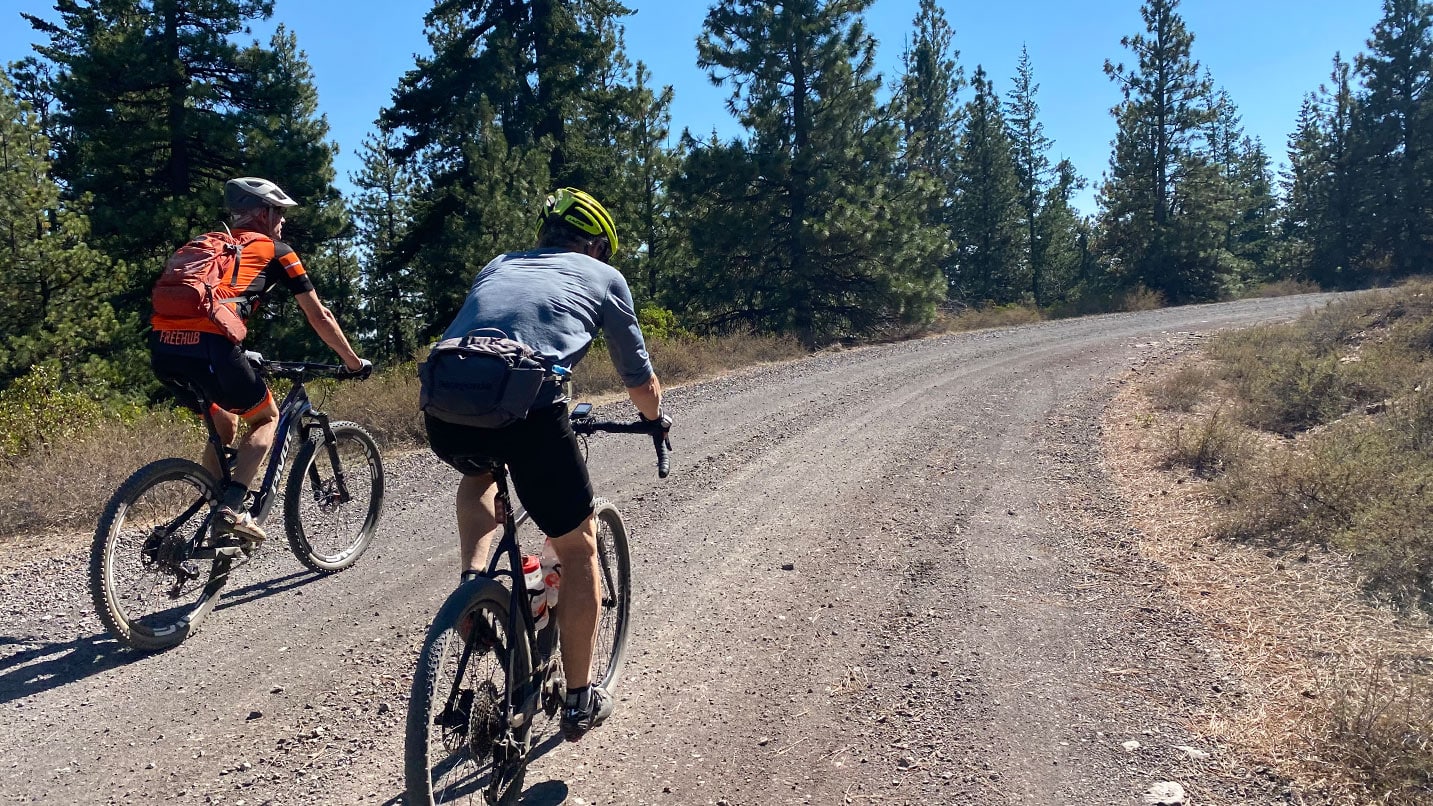 cyclists pedal away on gravel road