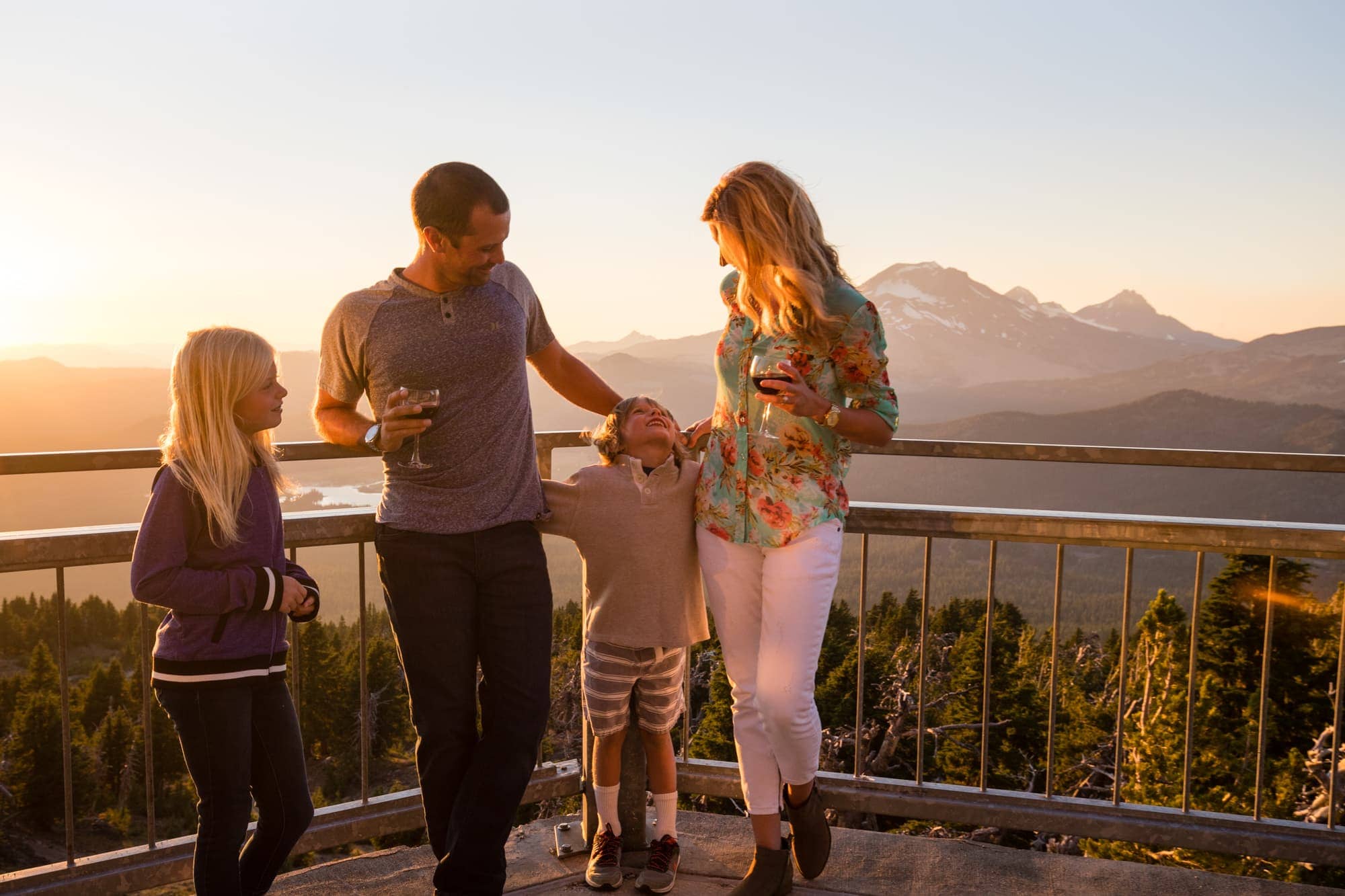 man, woman and two children at viewpoint with mountain in background