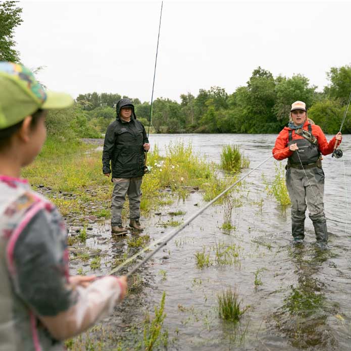 Gracie Mills teaches Lanessa and her daughter, Olivia, to fly fish.