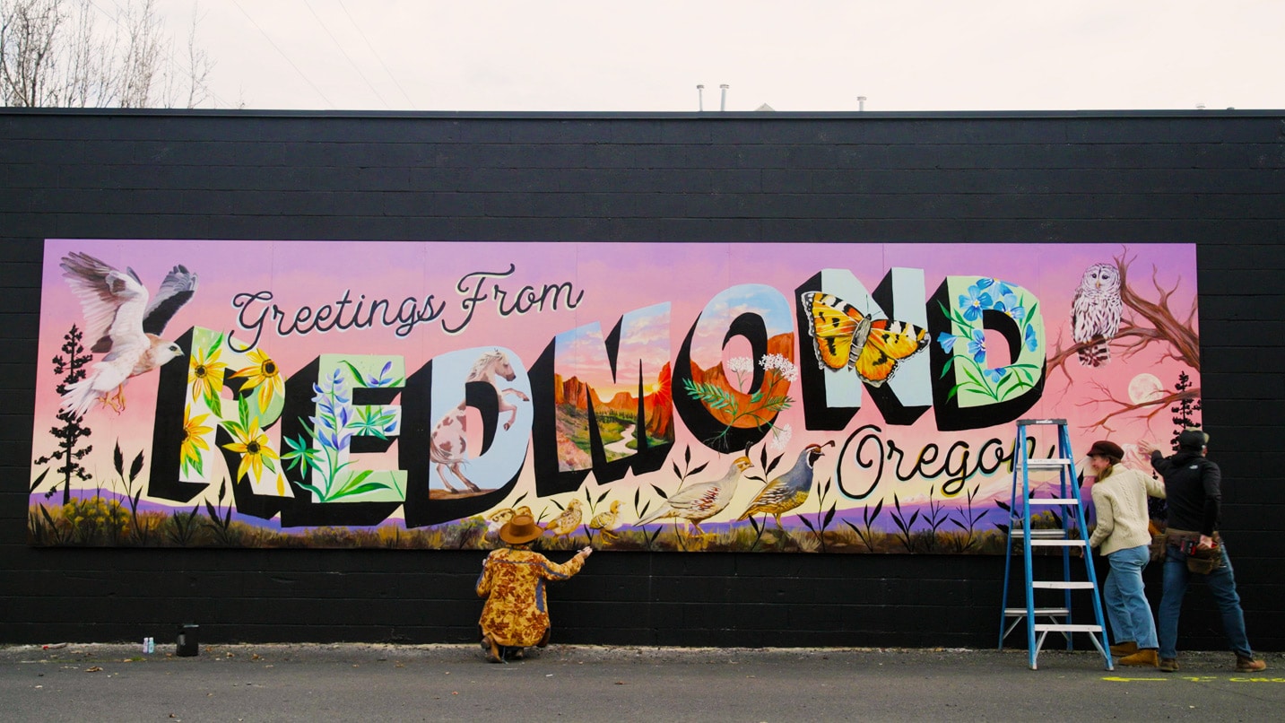 A colorful mural says "Greetings from Redmond, Oregon"