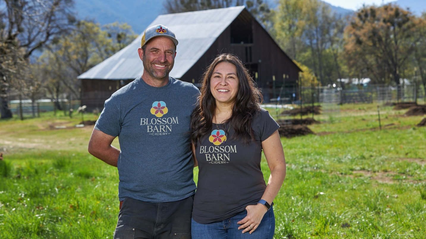 Man and woman in front of a barn.