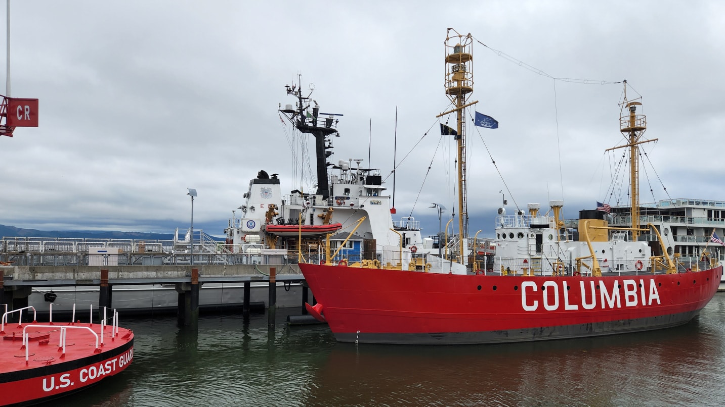 A large red ship printed with "Columbia" sits near the harbor.