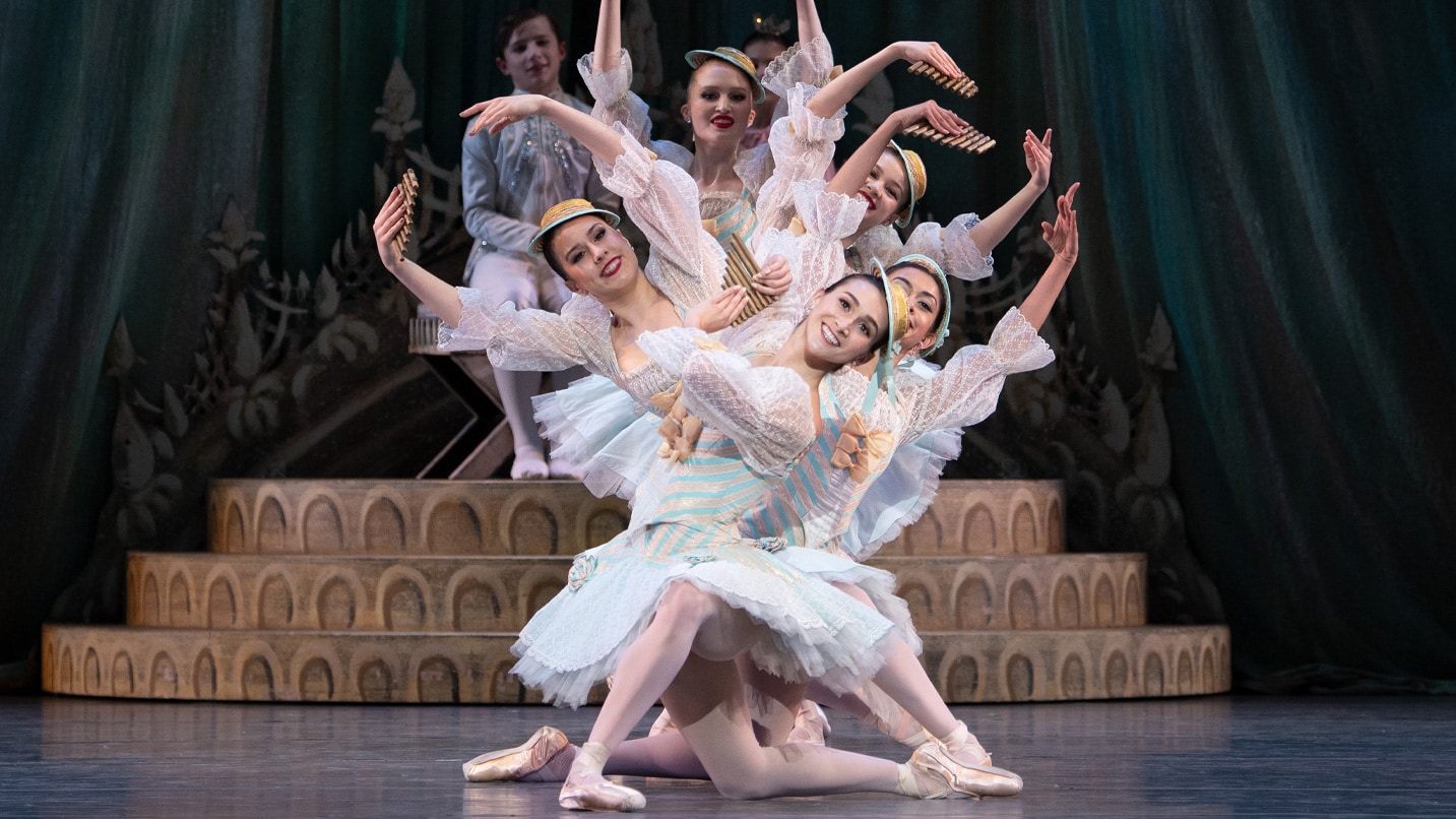 Ballet dancers performing a routine on stage.