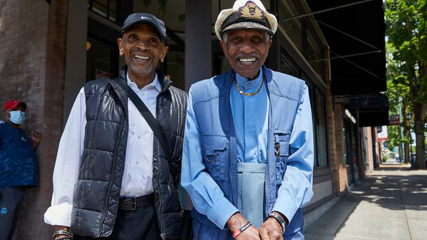 Two Black men smile broadly at the camera
