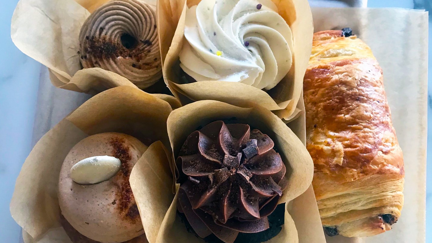 A variety of cupcakes and croissants on a table
