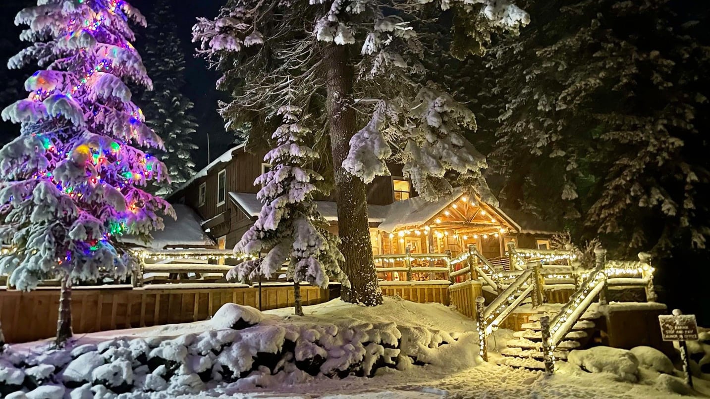 A snow covered lodge lit with holiday lights