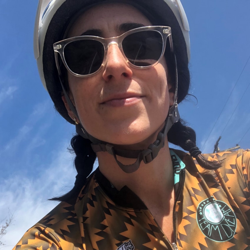 woman wears sunglasses and bike helmet