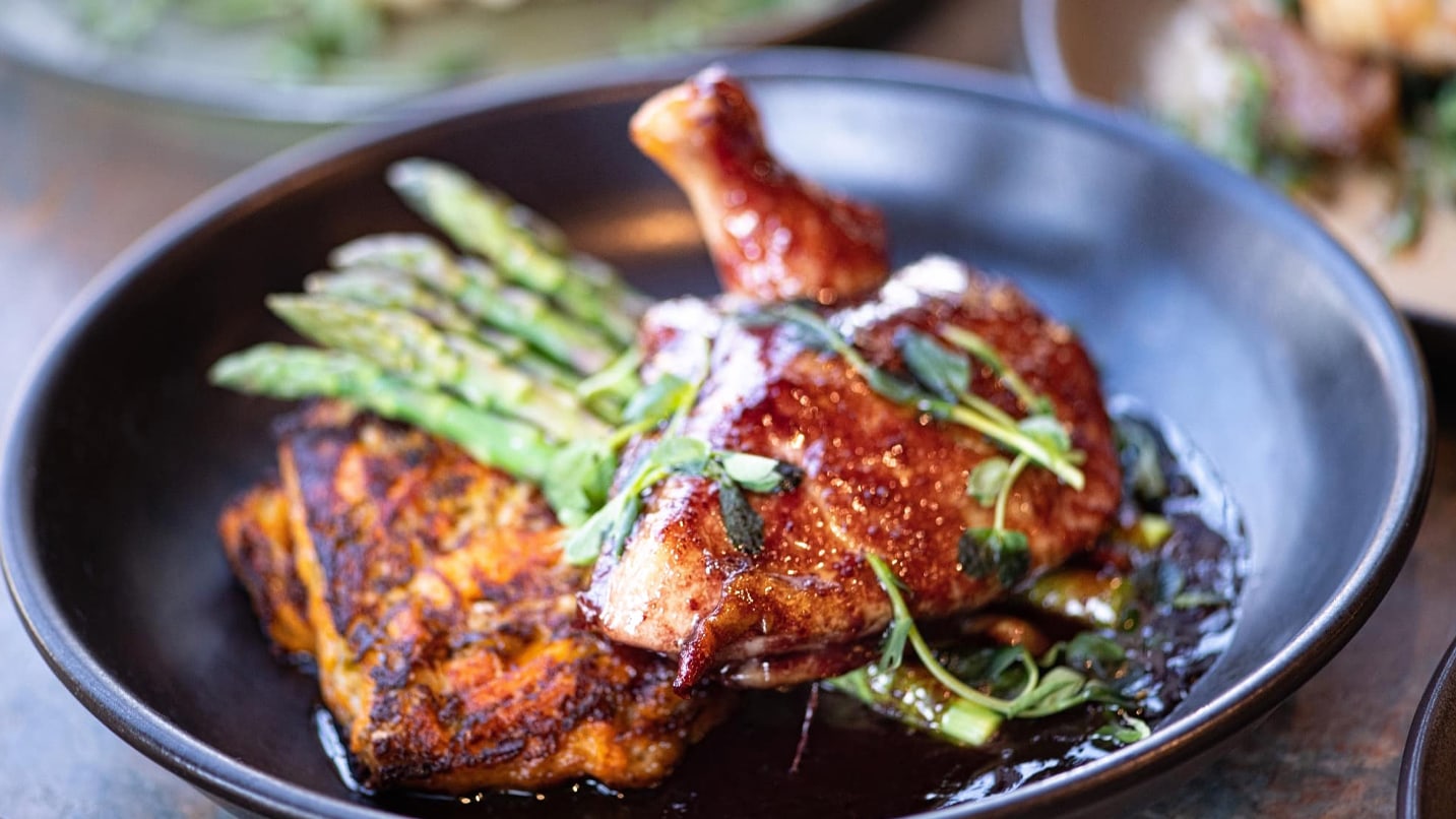 A plate of roasted chicken and asparagus.
