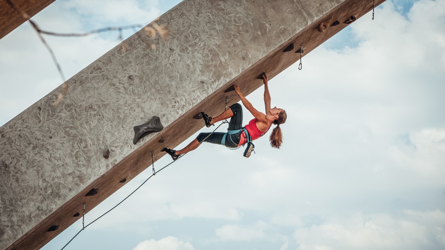 Woman recreation climbing on overhanging Maple Avenue Bridge.