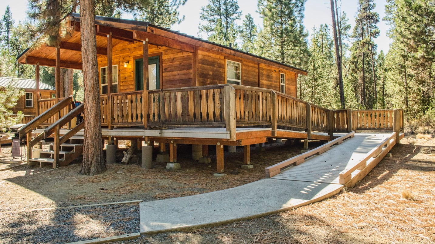 A log cabin with a wheelchair accessible ramp.
