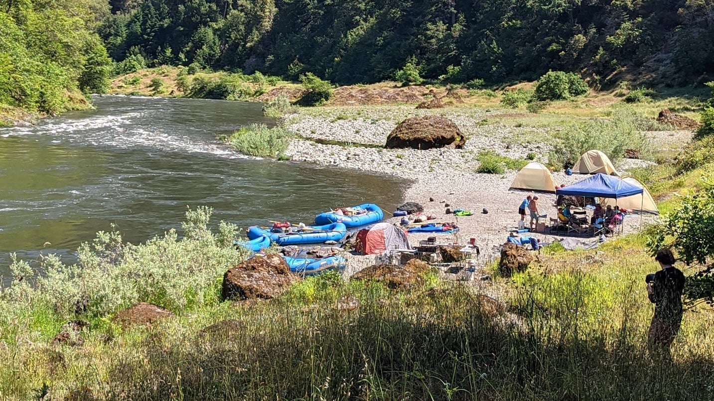 Several colorful rafts along a river shoreline.