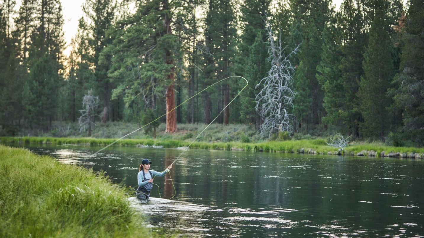 A woman casting a fishing line in the Deschutes River.