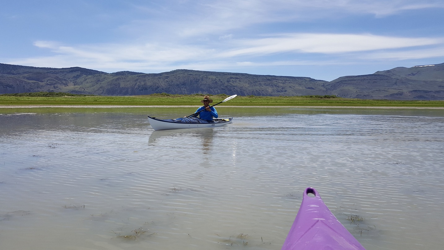 View of a man in a kayak on a lake.