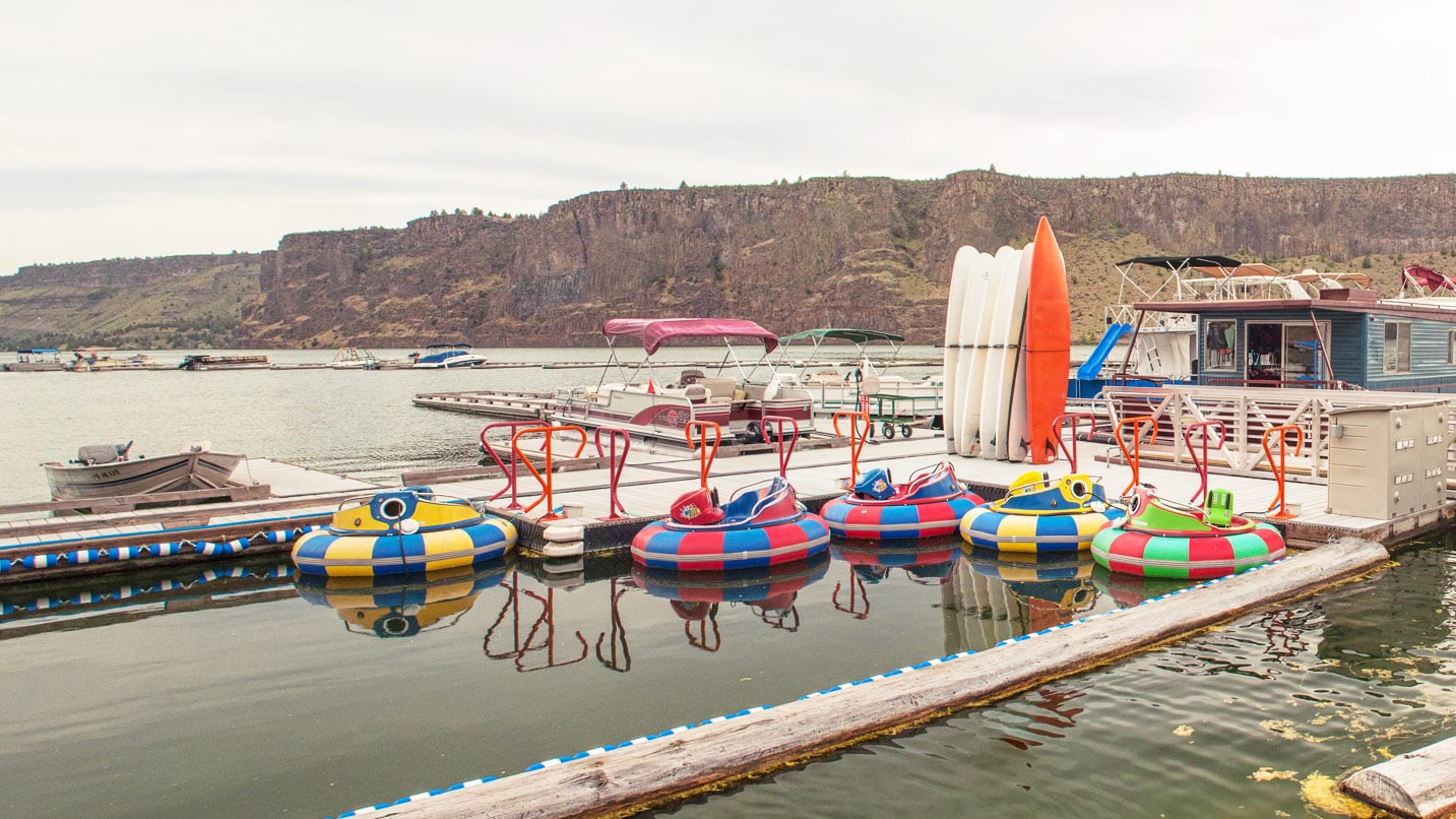 Large floating tubes and paddle boards near a dock for rent.