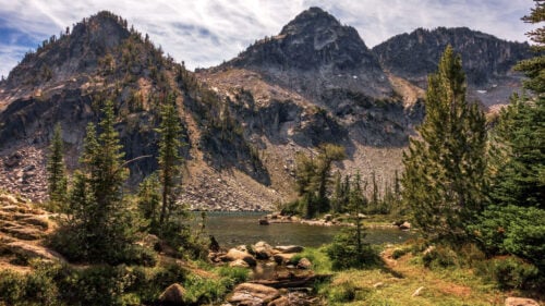 Maxwell Lake surrounded by evergreens and mountain range.