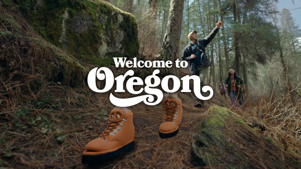 Puppet boots hiking on a trail. Text: Welcome to Oregon