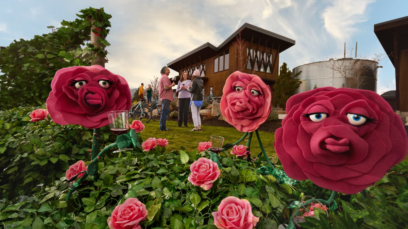 Puppet roses holding glasses of red wine.