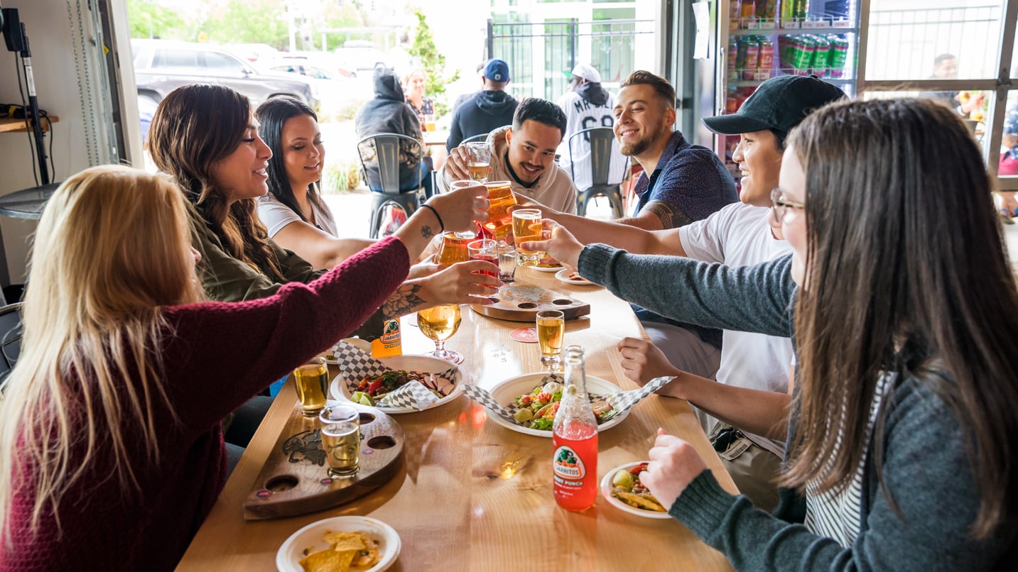 People toasting their cider at a table.