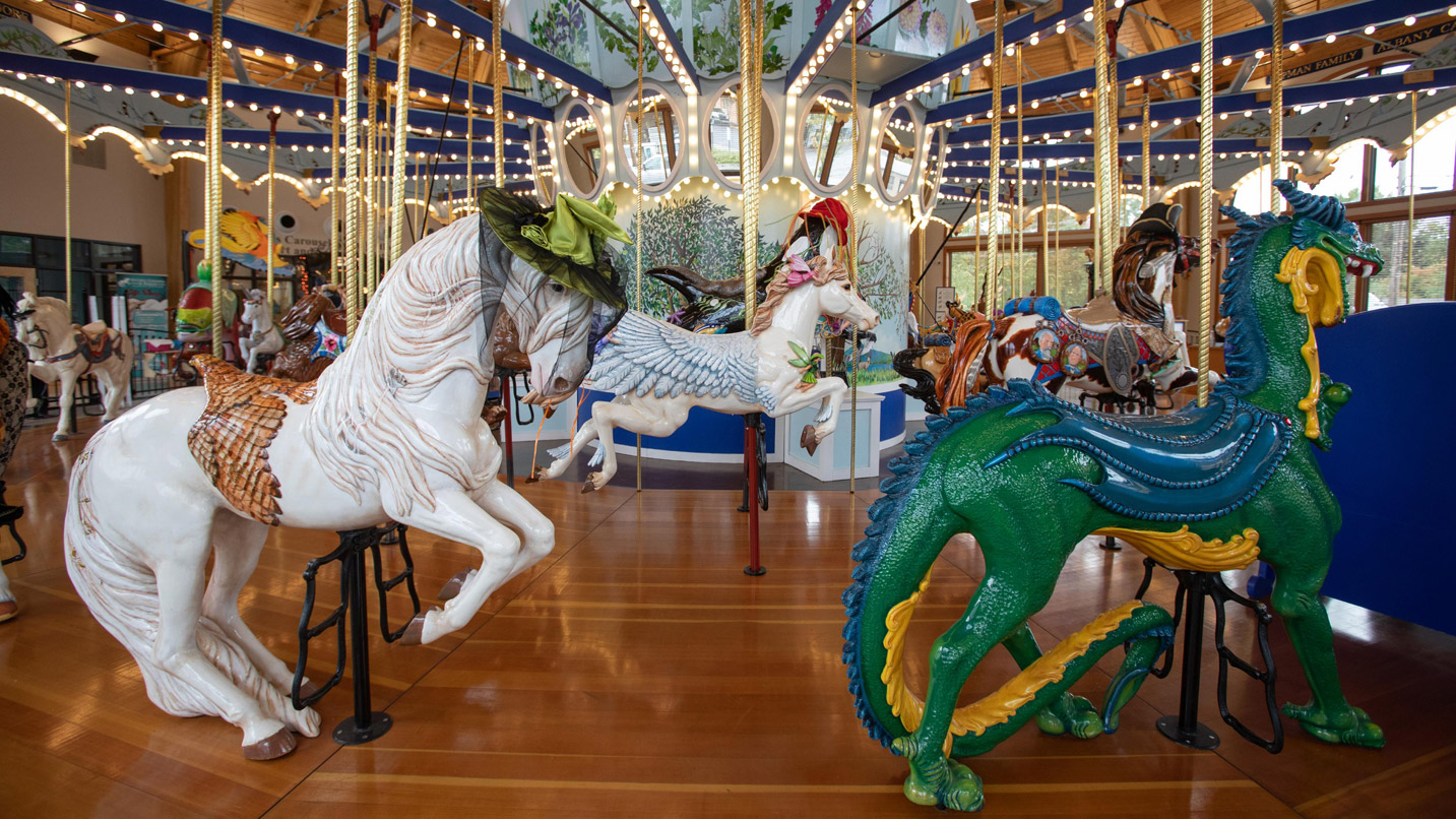 Carousel figurines. A horse wears a hat.