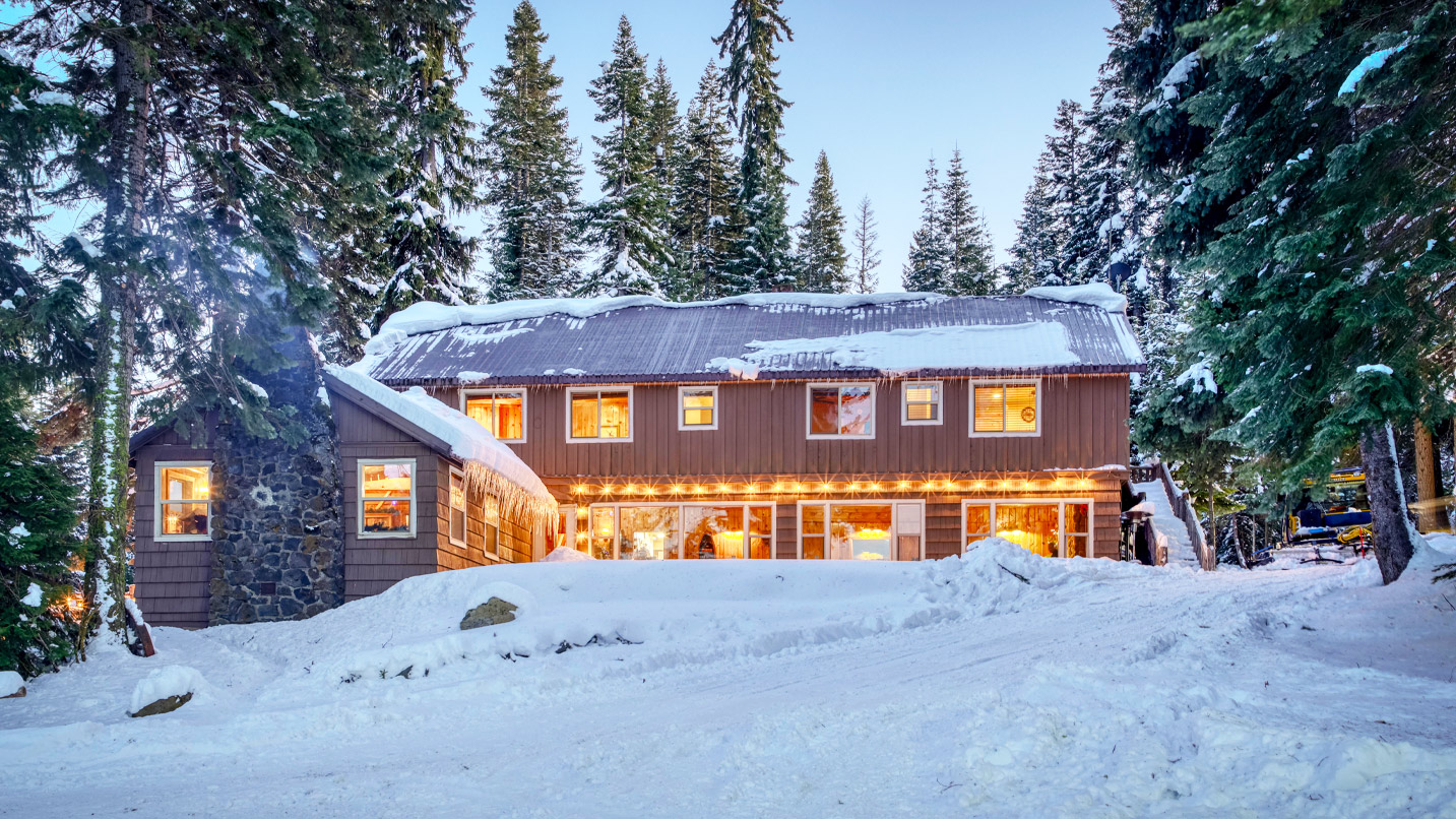 Large house in the forest surrounded by snow