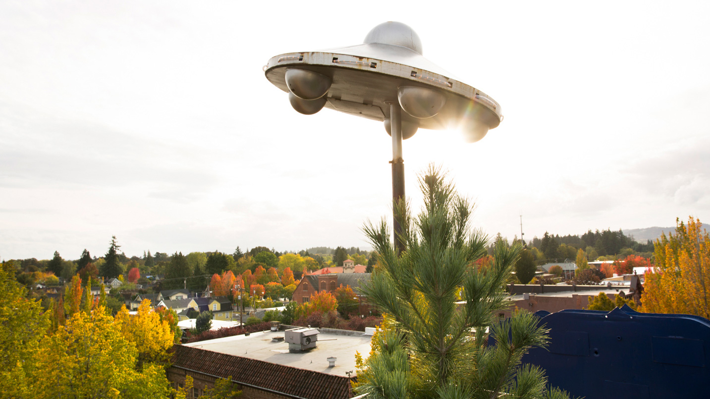 A sculpture of a UFO on a roof.