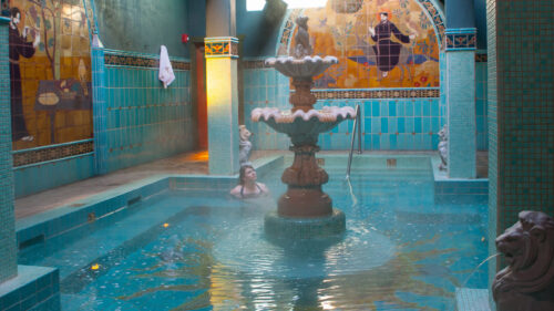 A jewel-like soaking pool surrounded in turquoise tile and old-fashioned wall frescos.