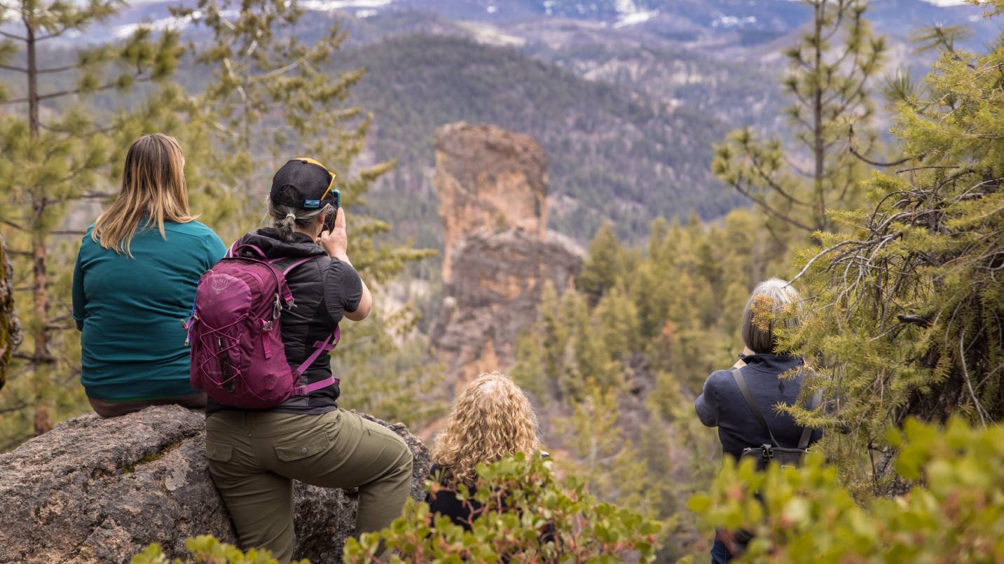 Group of people admire and take photos of a rock formation near Prineville.