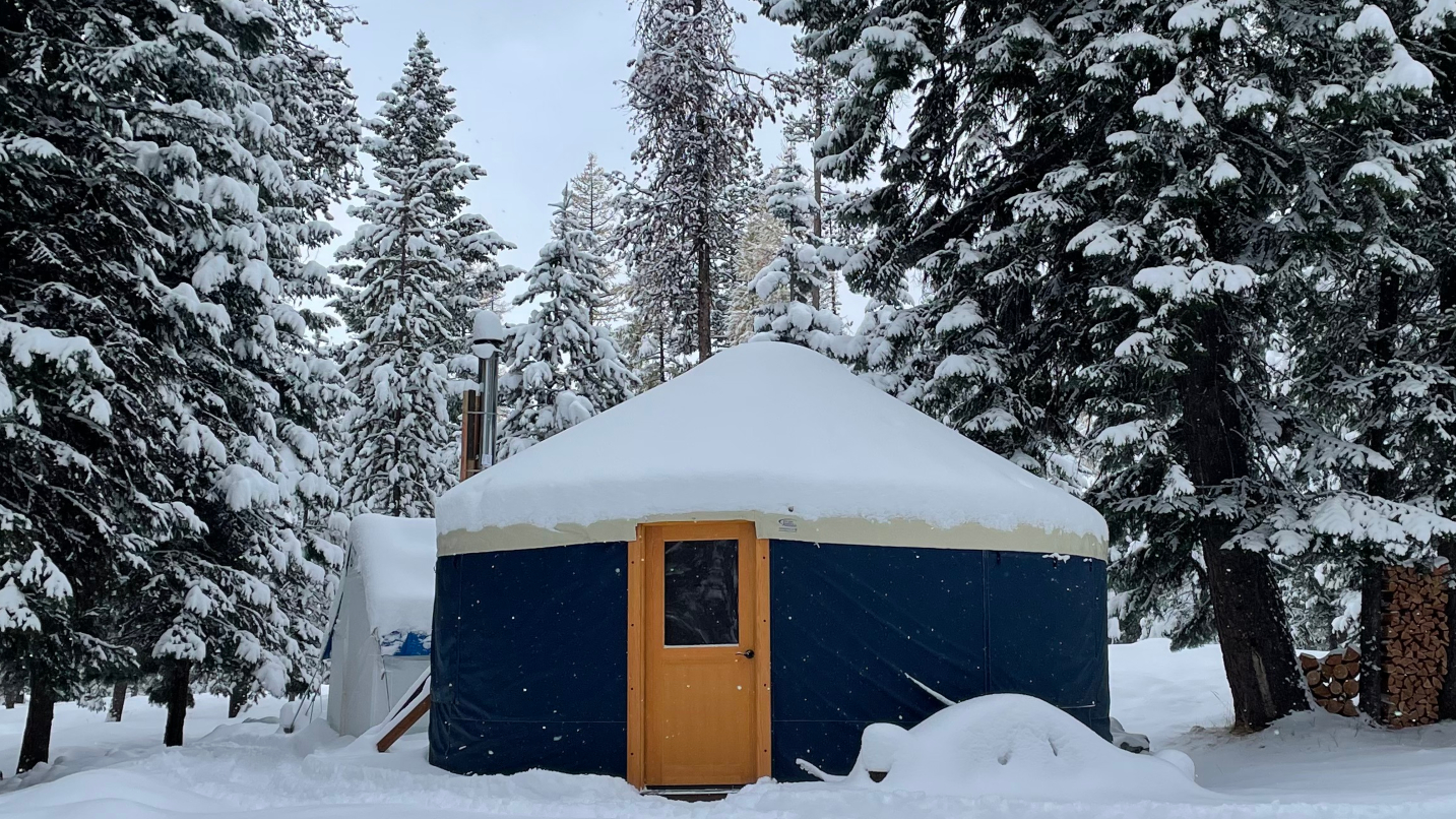 Yurt and tent in snowy forest