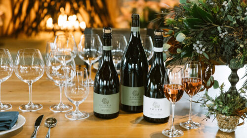 Soter wine bottles and wine glasses.