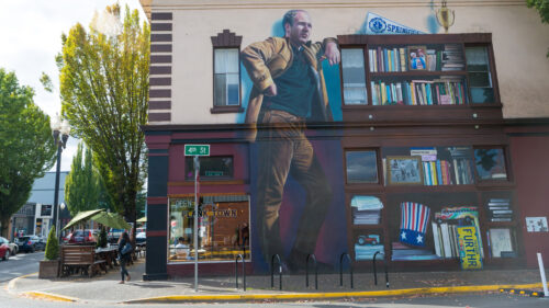 A mural of a man leaning against a bookshelf.
