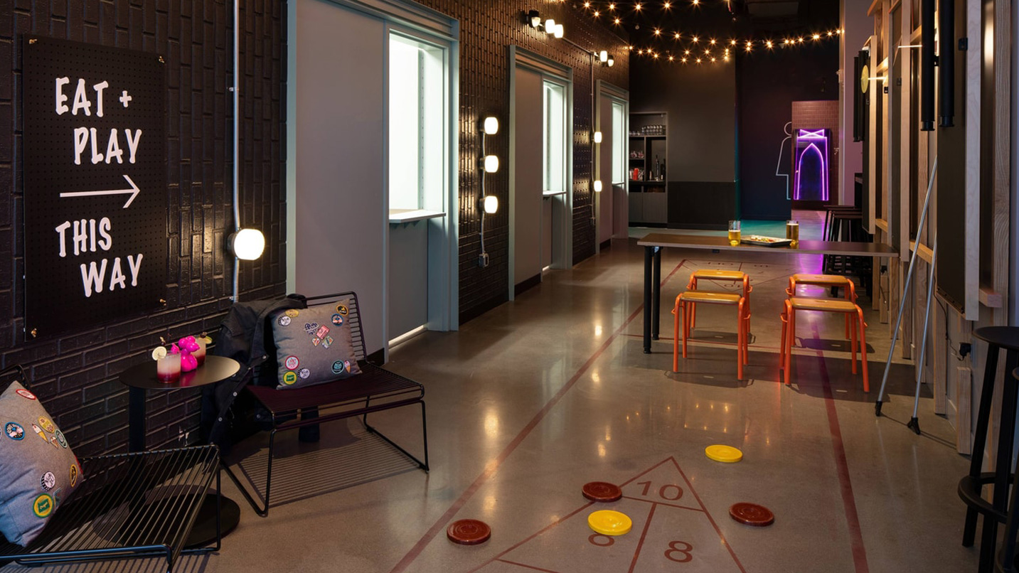 Large room shows spaces for floor game and playful lights and seating