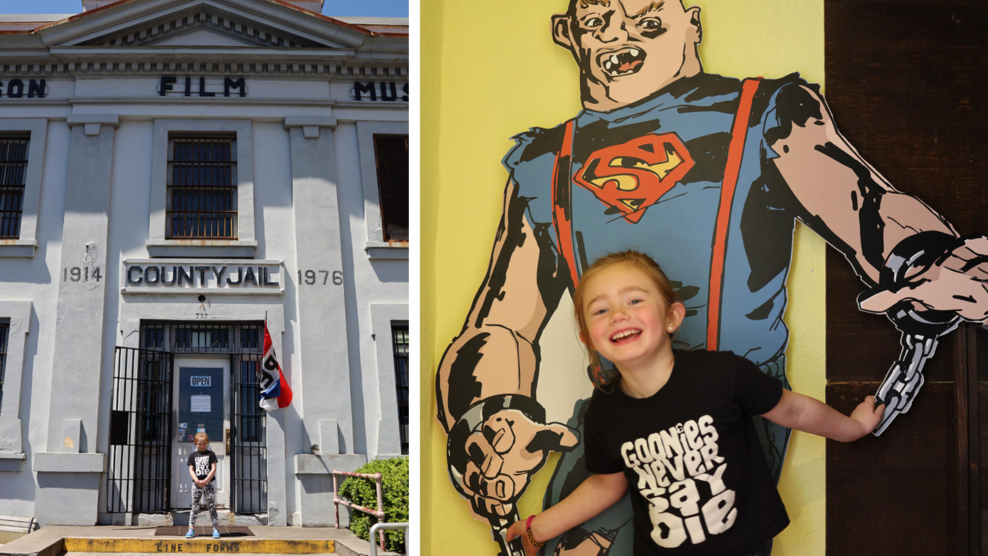Two collaged photos - on the left, a small child stands outside the now film museum, previously county jail building. On the right, the same child poses in front of a poster cutout of a "Goonies" character.