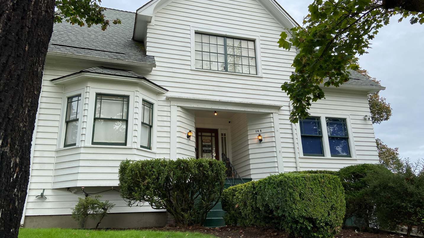 Exterior view of the Swan House, a white, 2-story Victorian home in St. Helens.
