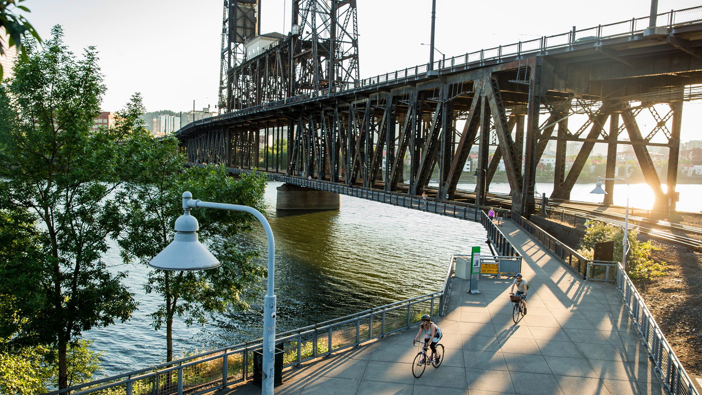 People biking on an urban bike trail under the Hawthorne Bridge.