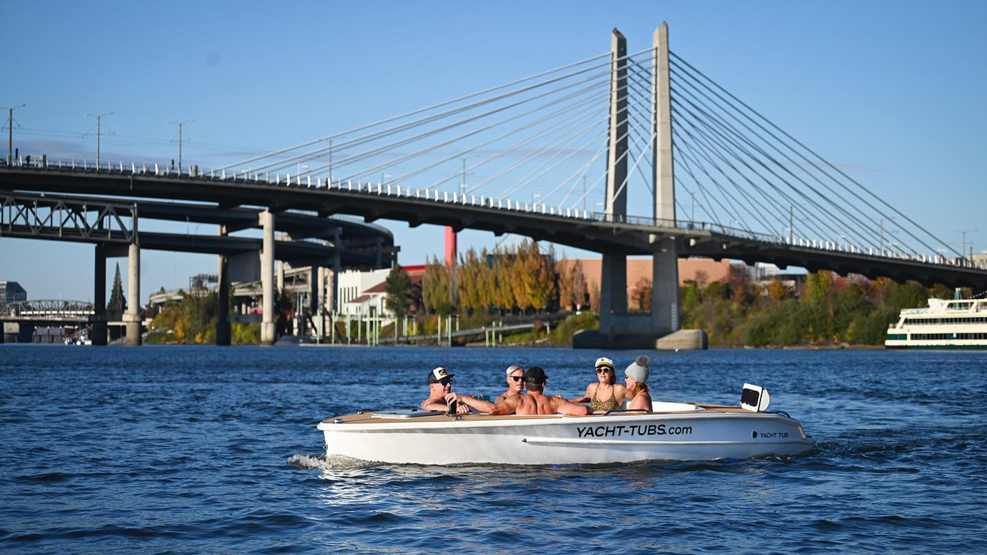 People in a floating hot tub in the middle of the Willamette River near the Tillamook Bridge in Portland.