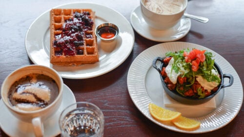 Plates of food and coffee on a table.