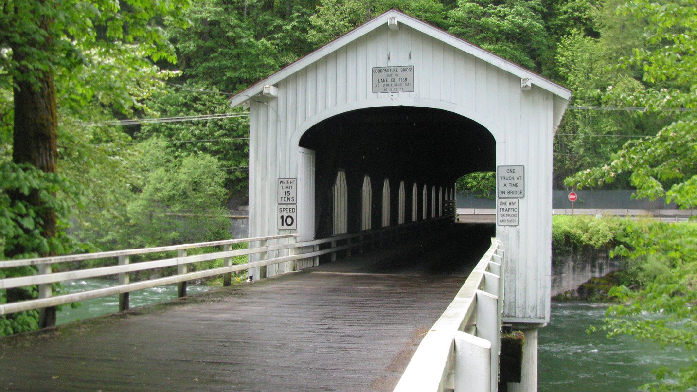 A white covered bridge spanning over a river.
