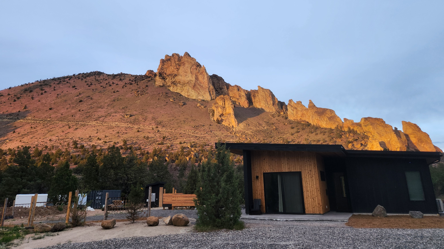 Building with large rock formation and blue sky in the background