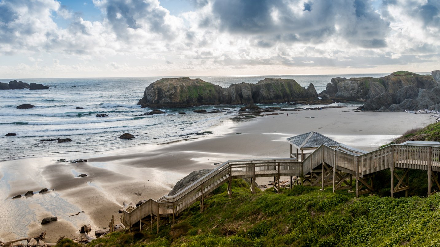Steep wooden stairs lead down to a beach.