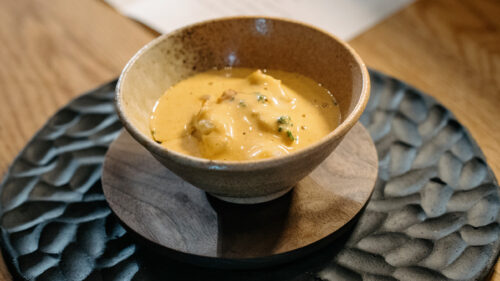 A small bowl of soup sits on a counter.
