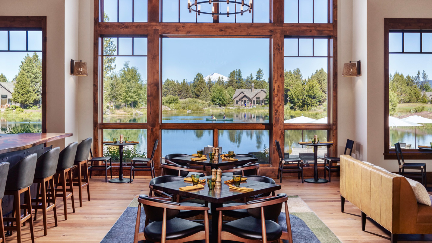 Dining room interior with views of a lake and mountain.