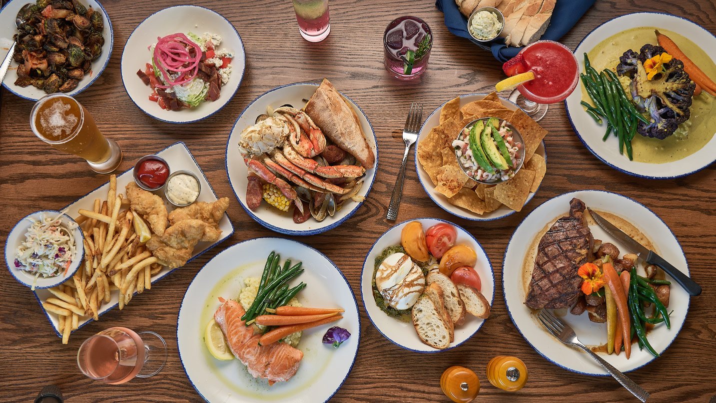 A table with many plates of food and drinks.