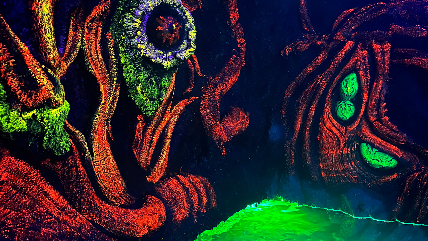 Glow in the dark mural of a dark forest inside a haunted house.