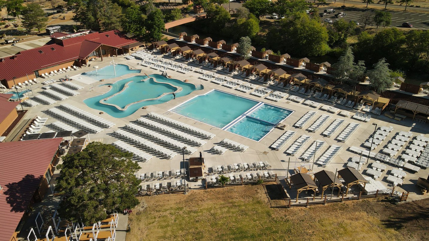 Aeriel view of pool area of the resort. The area spans three large pools with plenty of pool lounge chairs.
