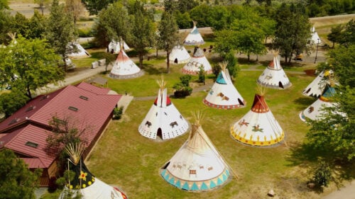 A grouping of tribal inspired teepee lodging on resort grounds.